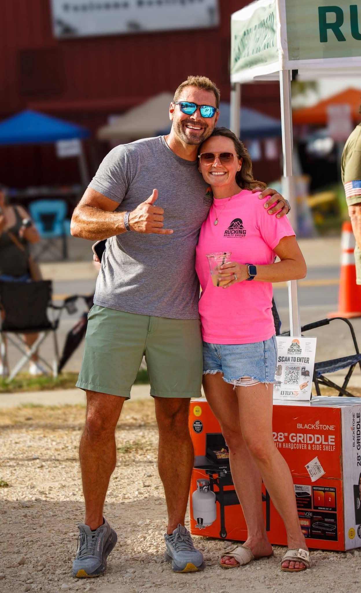 Mike and Natalie Evans at the Rucking Realty Group booth at the Lytle 75th anniversary celebration, Natalie in a Rucking Realty Group shirt