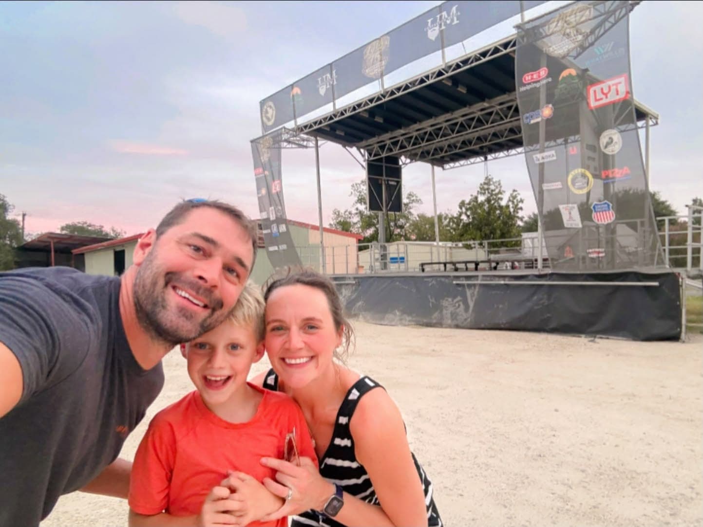 Mike and Natalie Evans with their son, taking a selfie in front of the stage at the Lytle 75th anniversary celebration